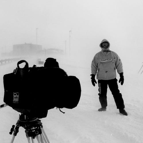 A dimly lit film set with a crew working under neon lights, creating an artistic atmosphere.